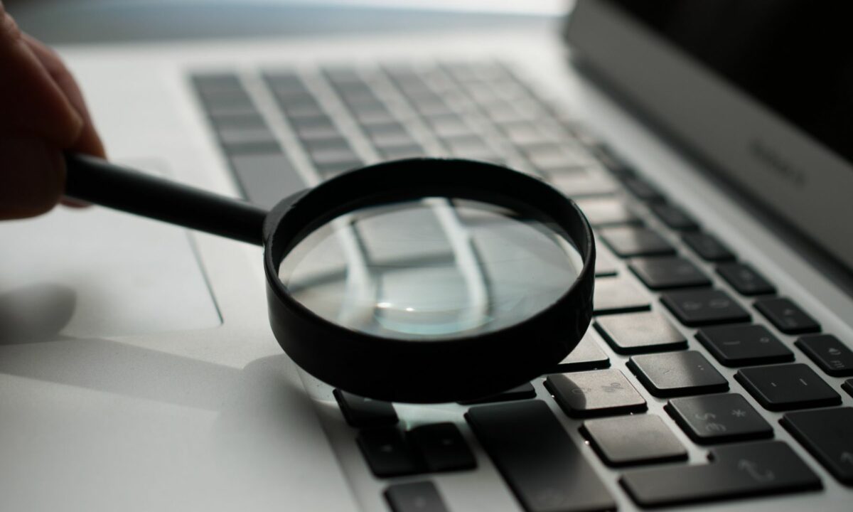A magnifying glass over a keyboard depicts a particular search tool.