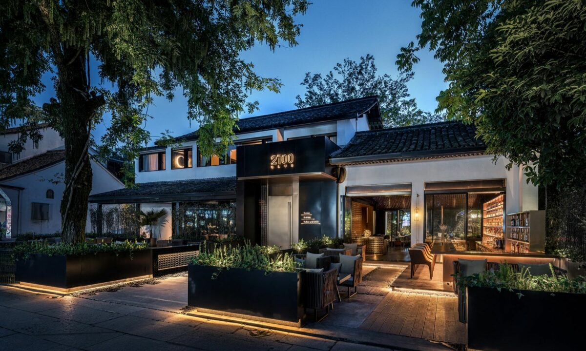 A luxurious, modern, contemporary real estate commercial property exterior with alfresco dining over a night sky.