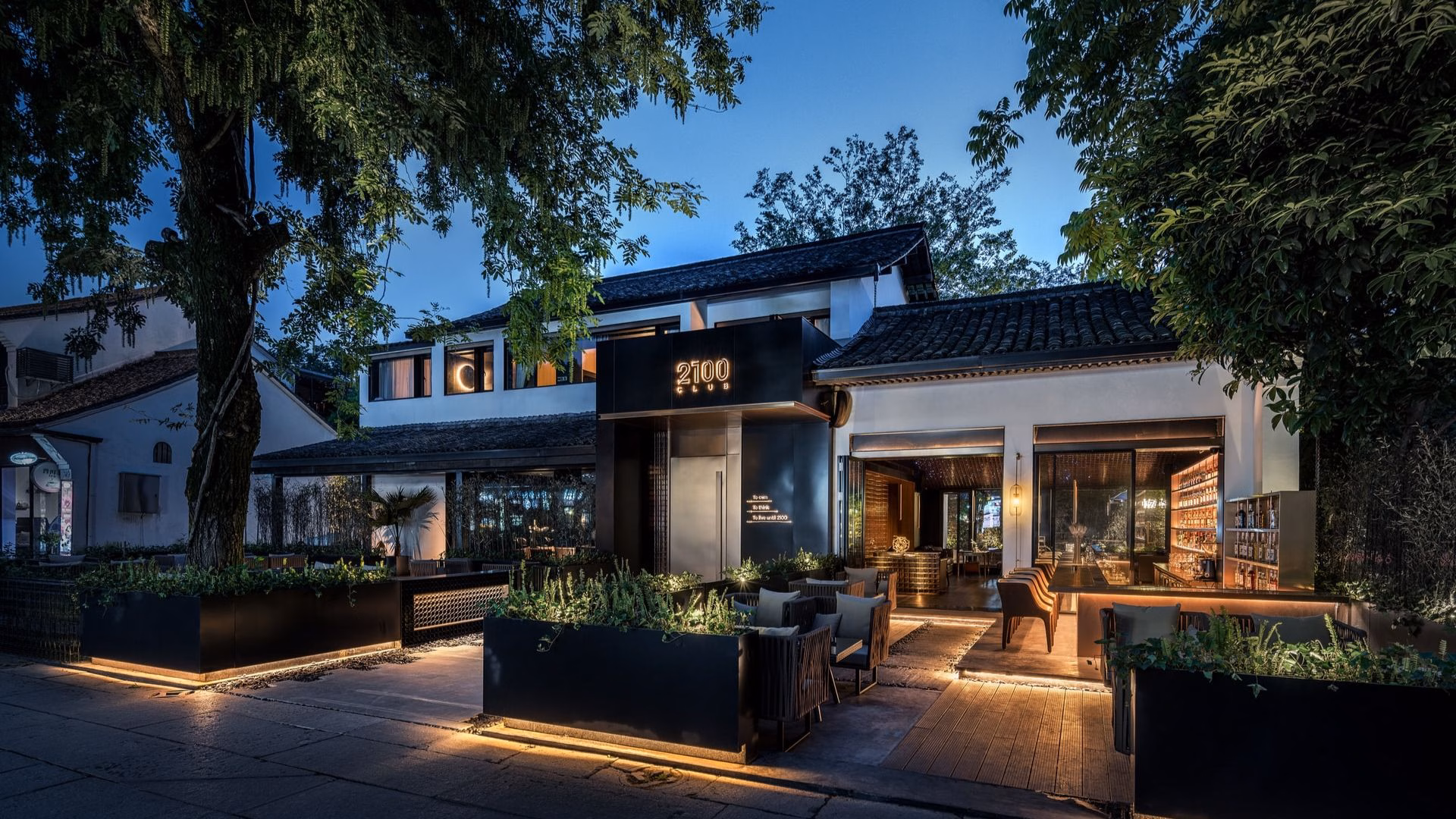 A luxurious, modern, contemporary real estate commercial property exterior with alfresco dining over a night sky.