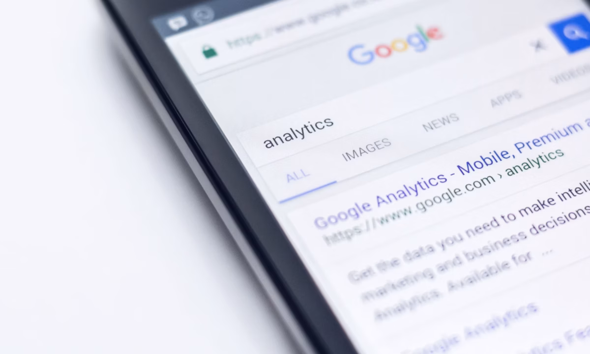 A mobile phone showing a Google search result about analytics on the first page.