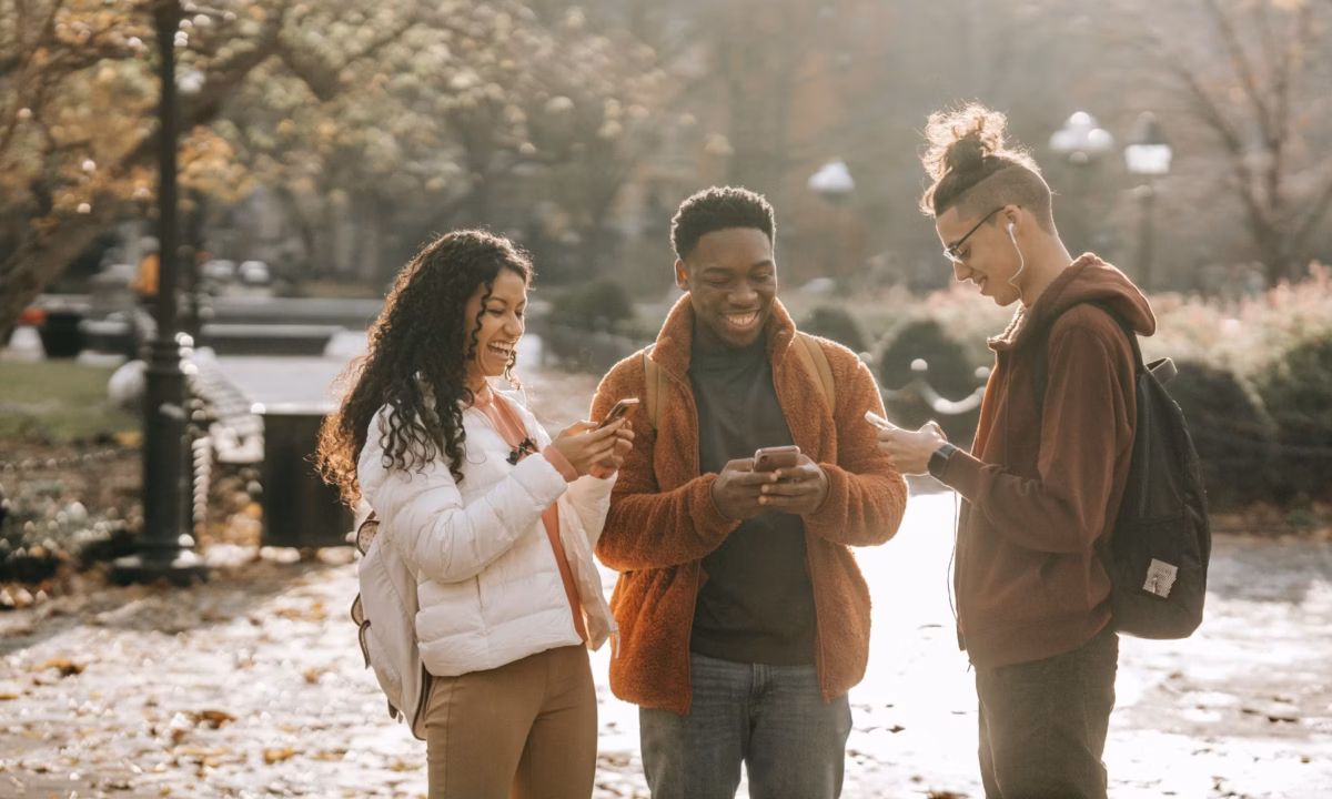 A group of people casually browsing social media on their mobile phones.