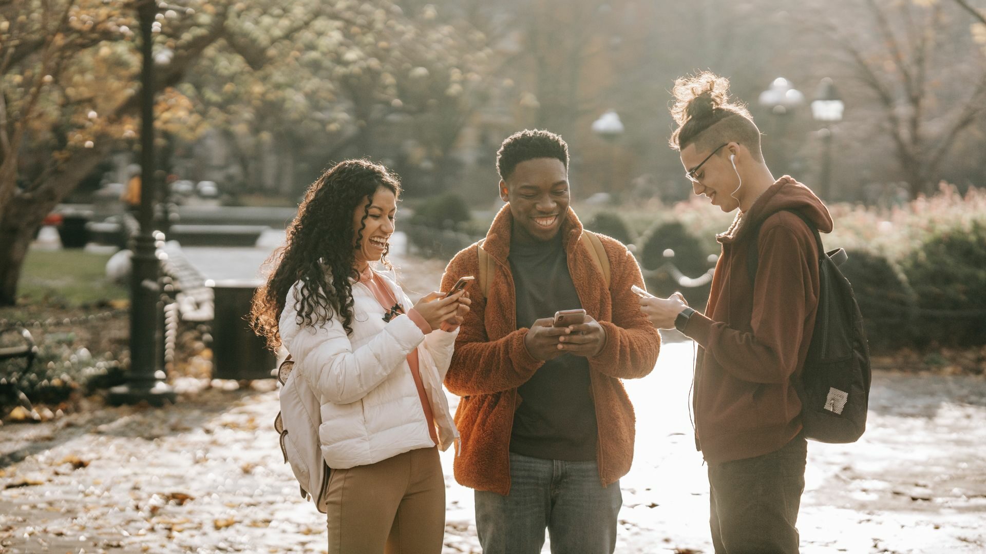 A group of people casually browsing social media on their mobile phones.