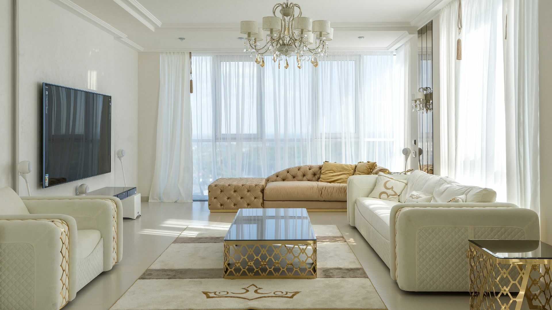 Interior design of a luxurious, clean, white, gold, and modern living room with a large, flat television.