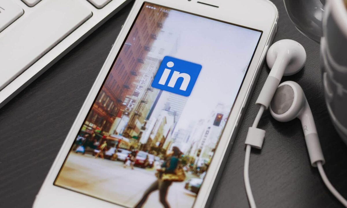 A mobile phone showing a wallpaper with the LinkedIn logo.