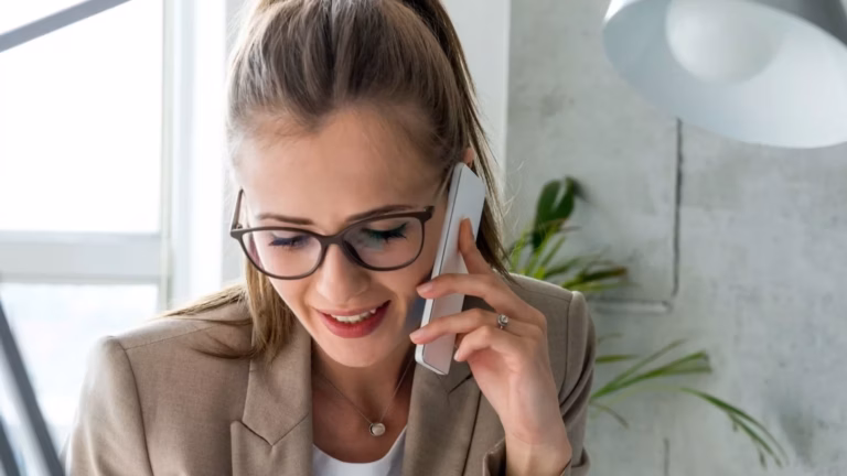 A woman practicing successful real estate lead follow-up on the phone.