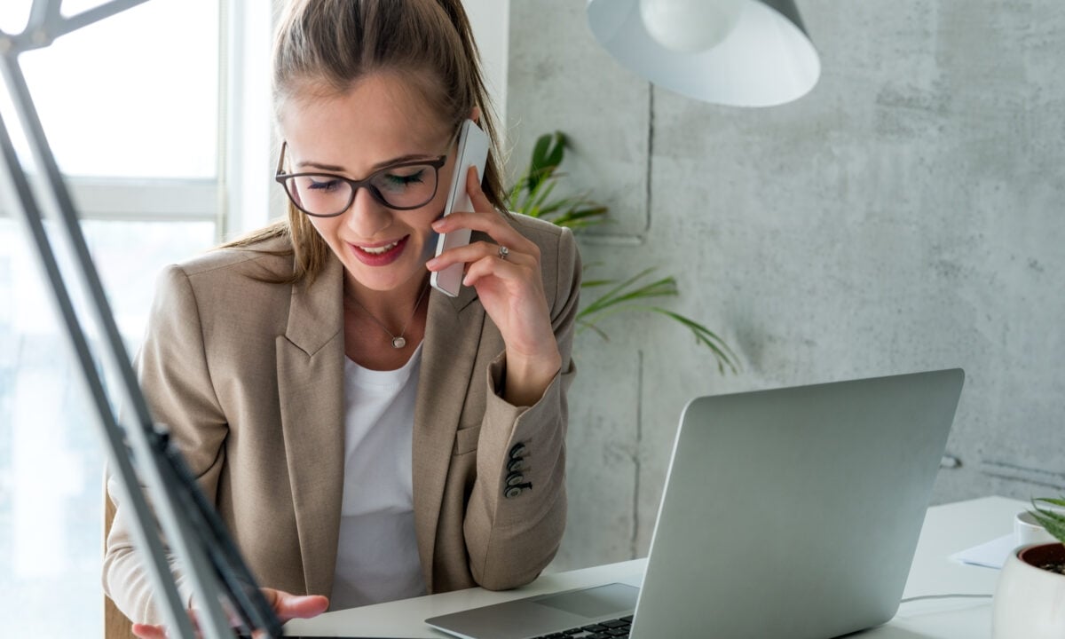 An agent is on the phone managing her real estate transaction coordination