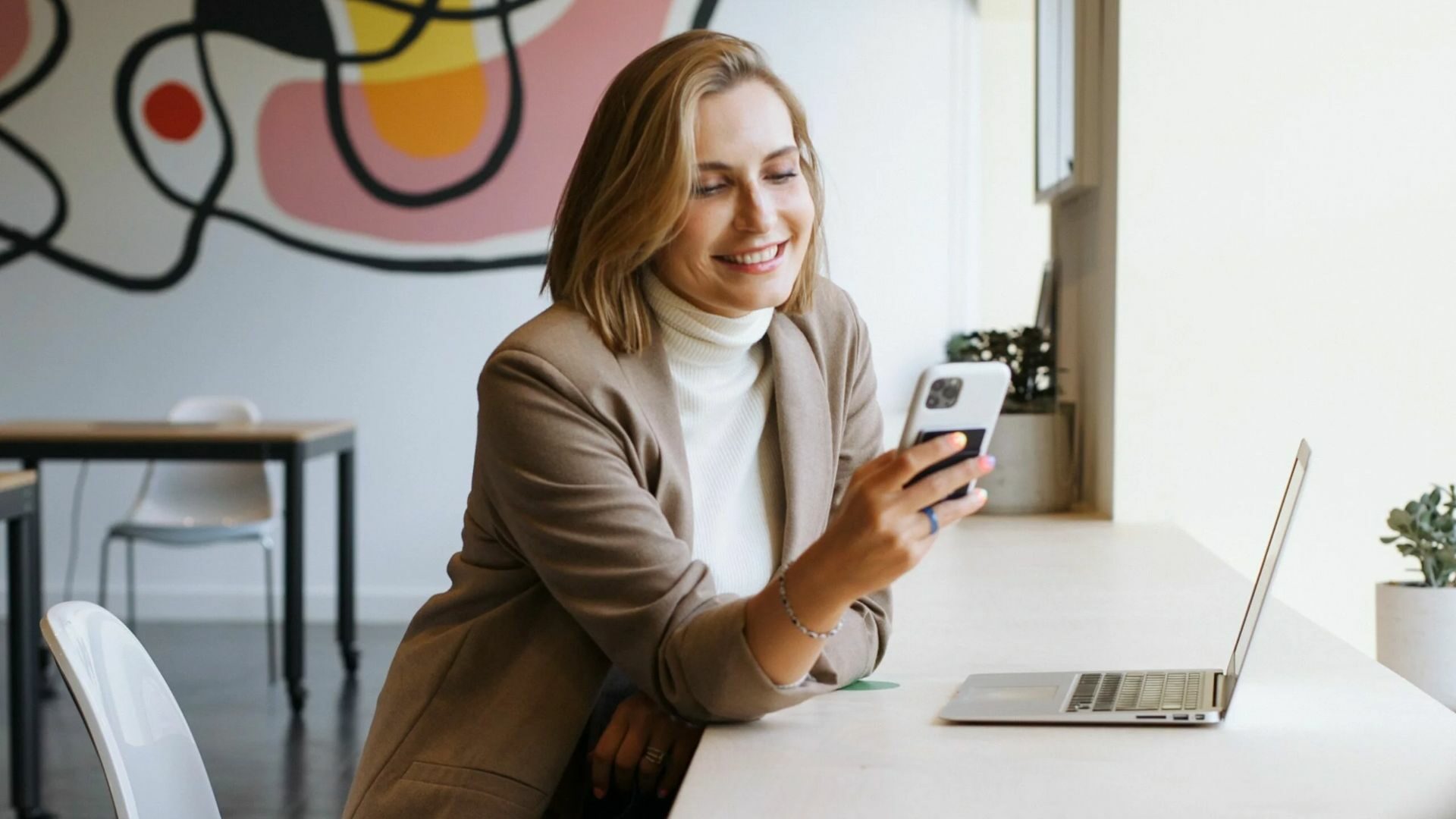 A cheerful realtor is learning how to use social media effectively for their marketing strategy from her phone.