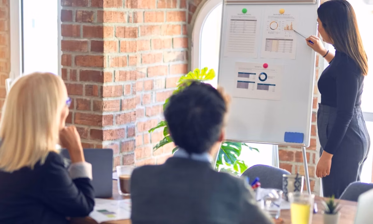 A senior realtor discusses their marketing plans with her team to achieve their goals and stay on top of the competition.