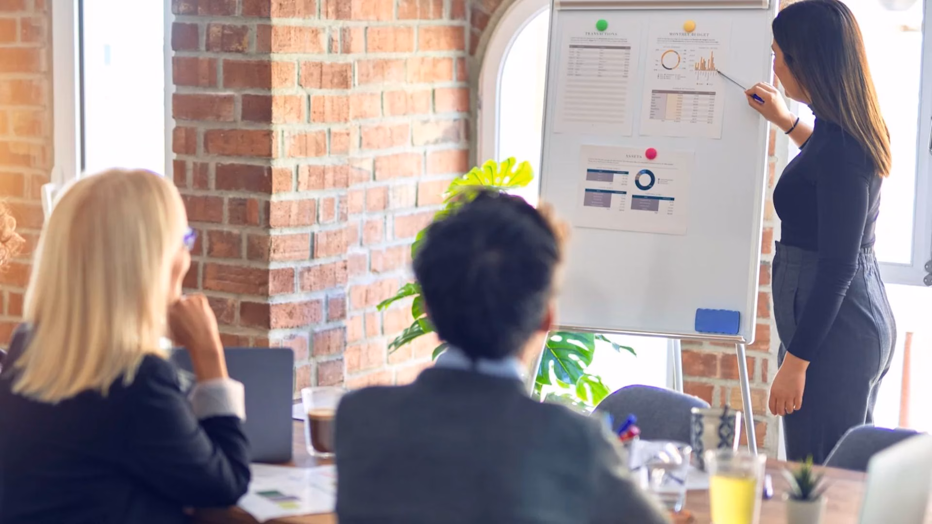 A senior realtor discusses their marketing plans with her team to achieve their goals and stay on top of the competition.