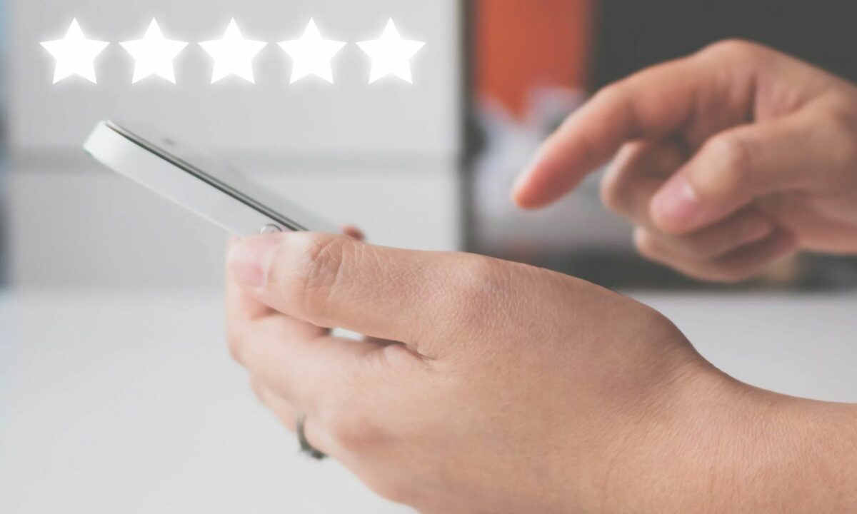 A customer gives a five-star online review to a real estate agent.