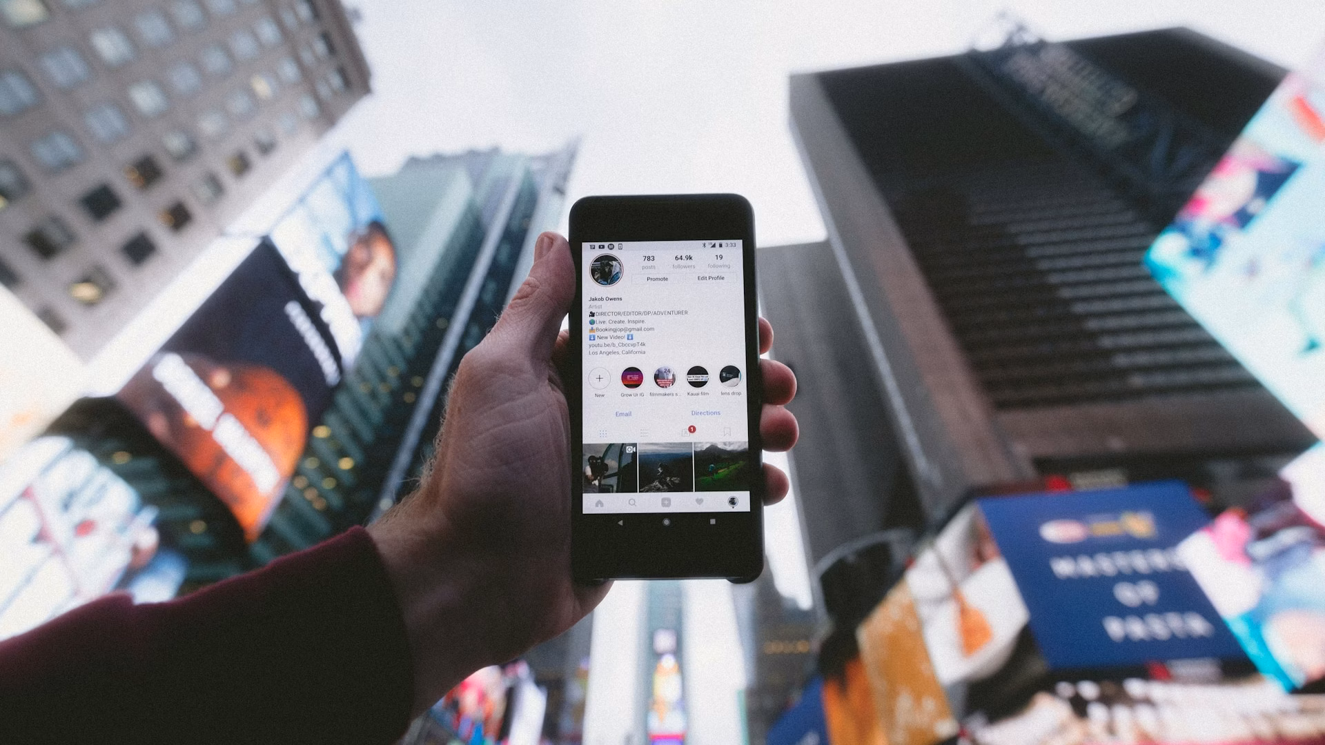 real estate agent holding a phone up to a city skyline