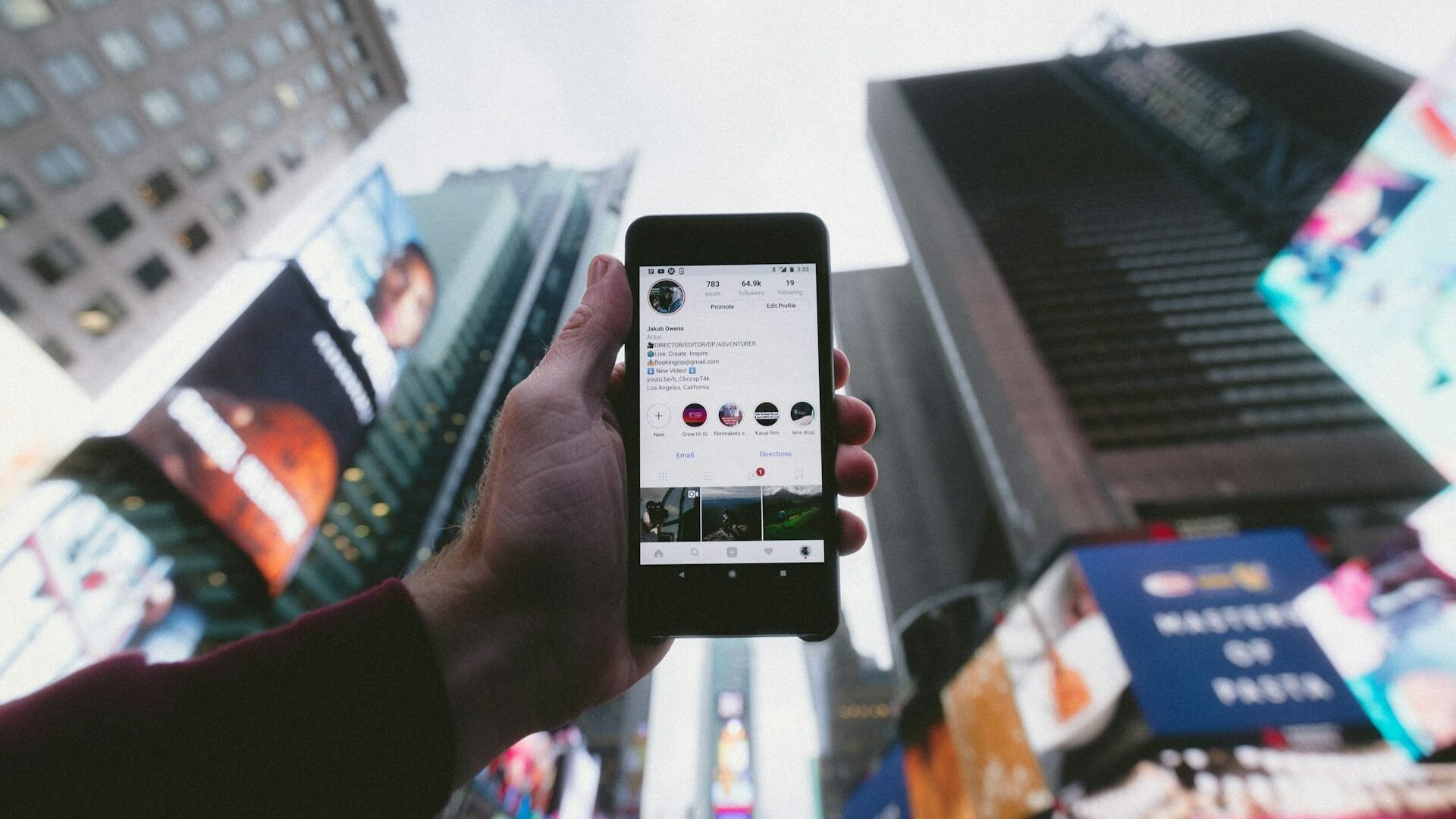 real estate agent holding a phone up to a city skyline
