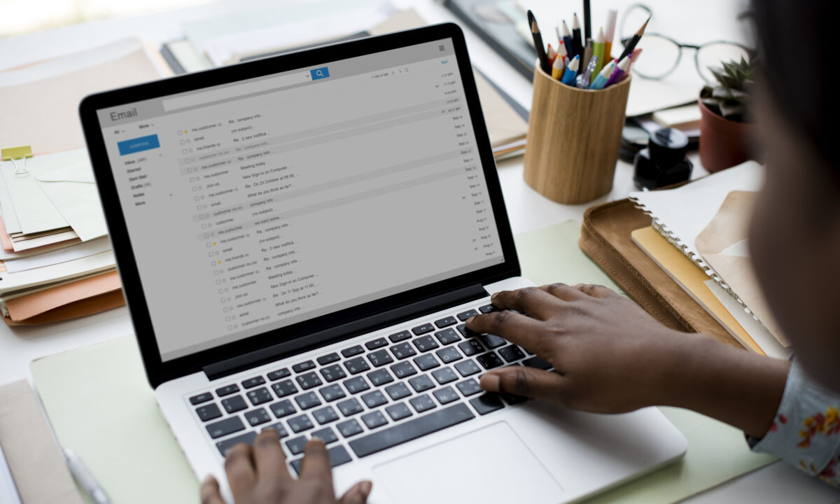 A real estate agent uses a laptop for email automation.