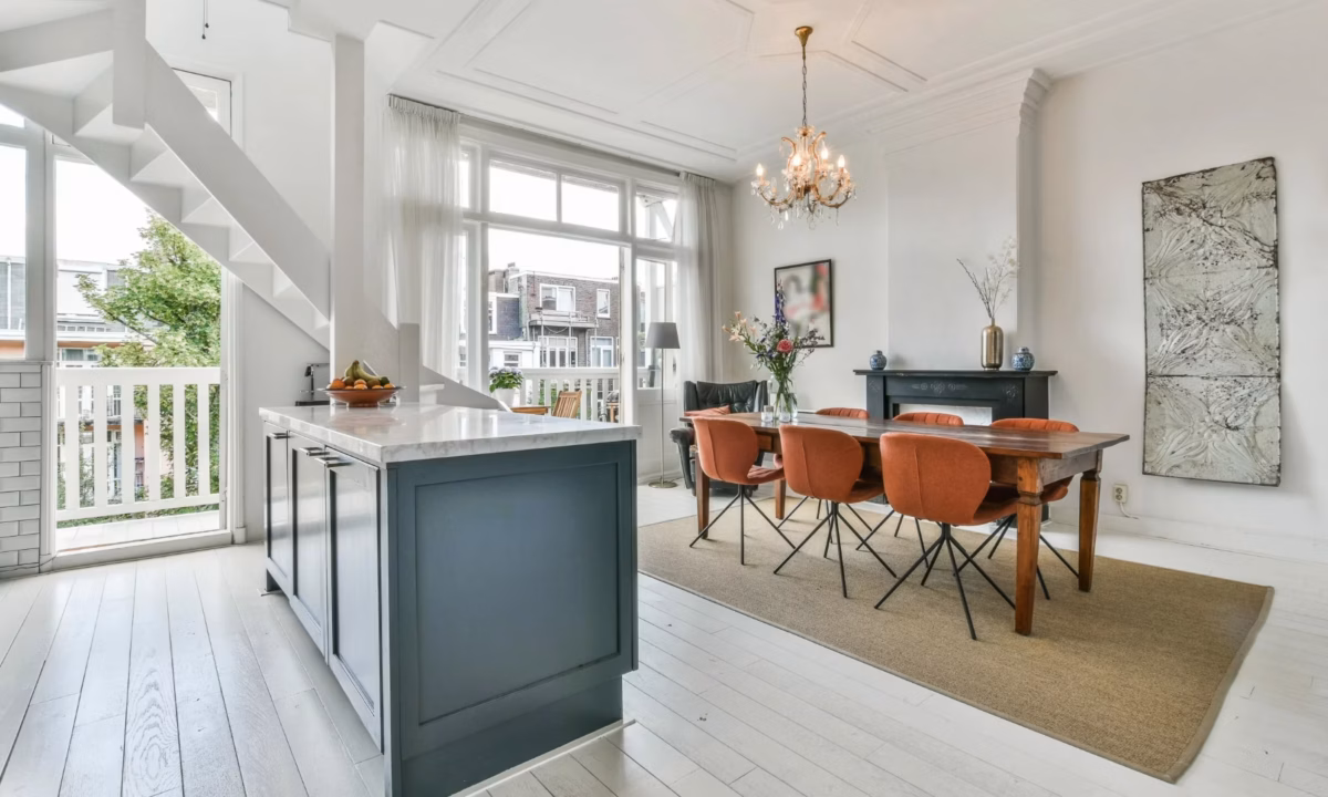 A clean and modern view of a kitchen island with dining area.