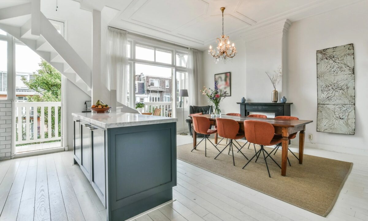 A clean and modern view of a kitchen island with dining area.