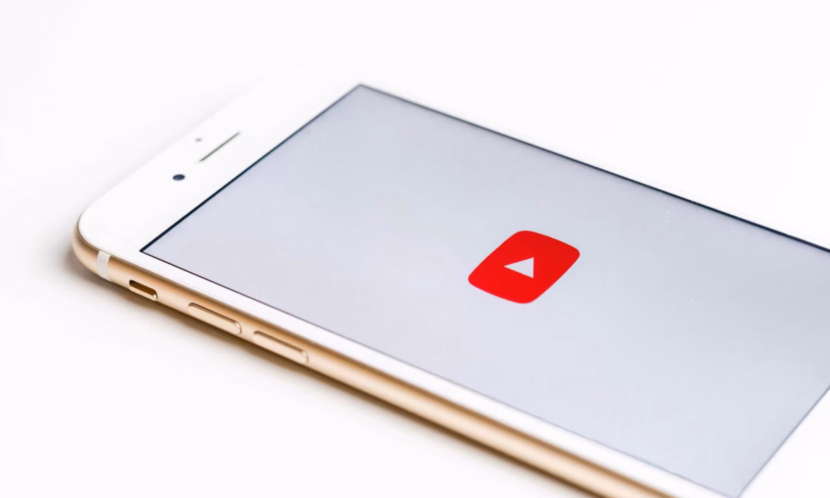 A mobile phone showing the logo of YouTube for blog about starting a real estate youtube channel.