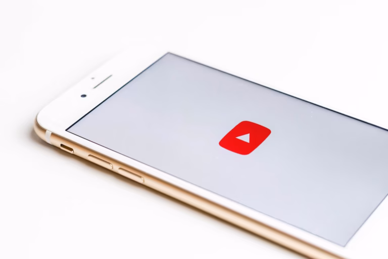 A mobile phone showing the logo of YouTube for blog about starting a real estate youtube channel.