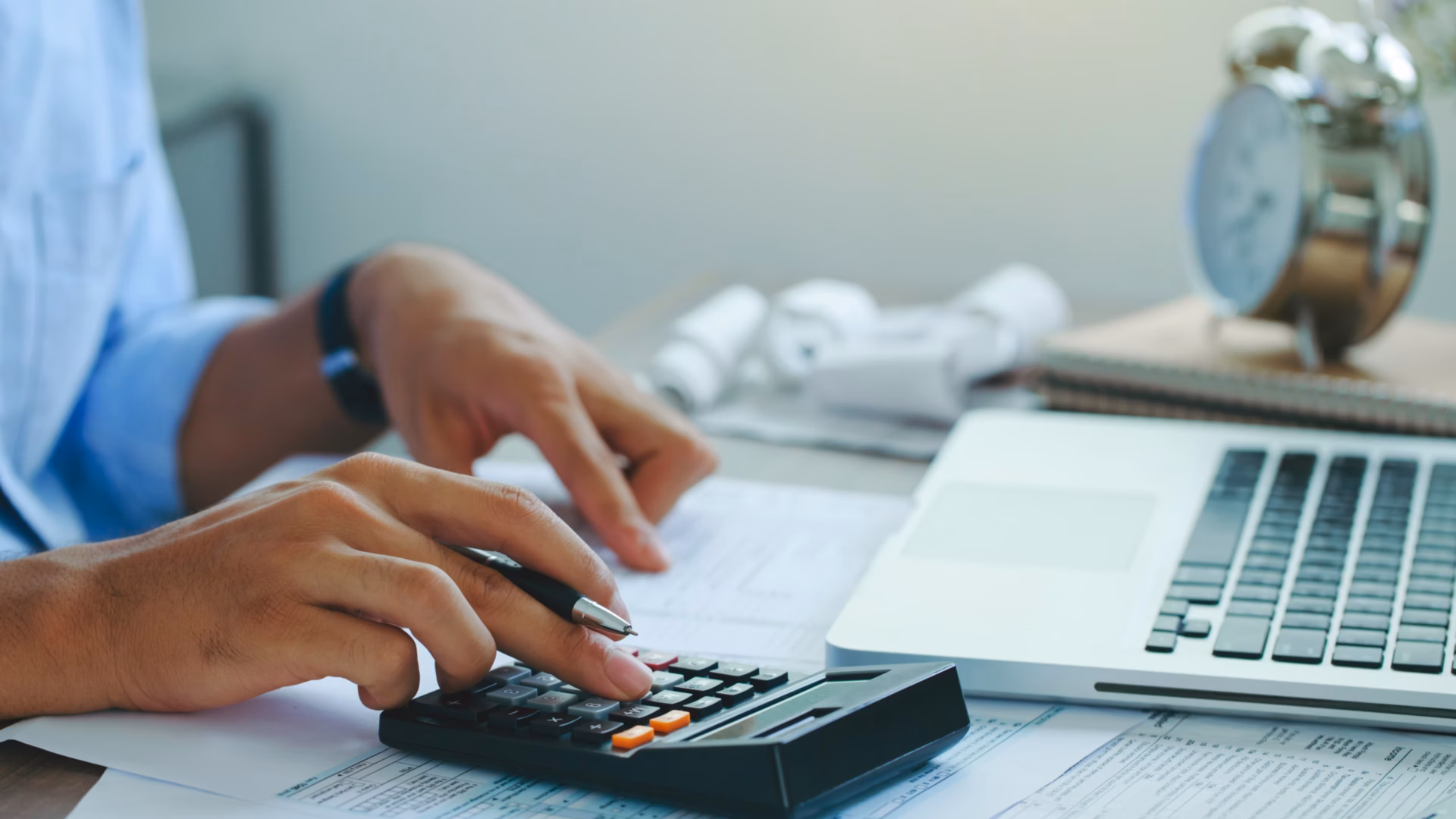 A real estate agent uses his calculator to work out real estate math formulas.