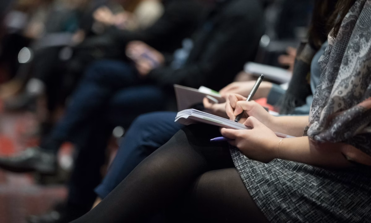 A row of agents sit taking notes in one of the best real estate negotiation classes available in the industry
