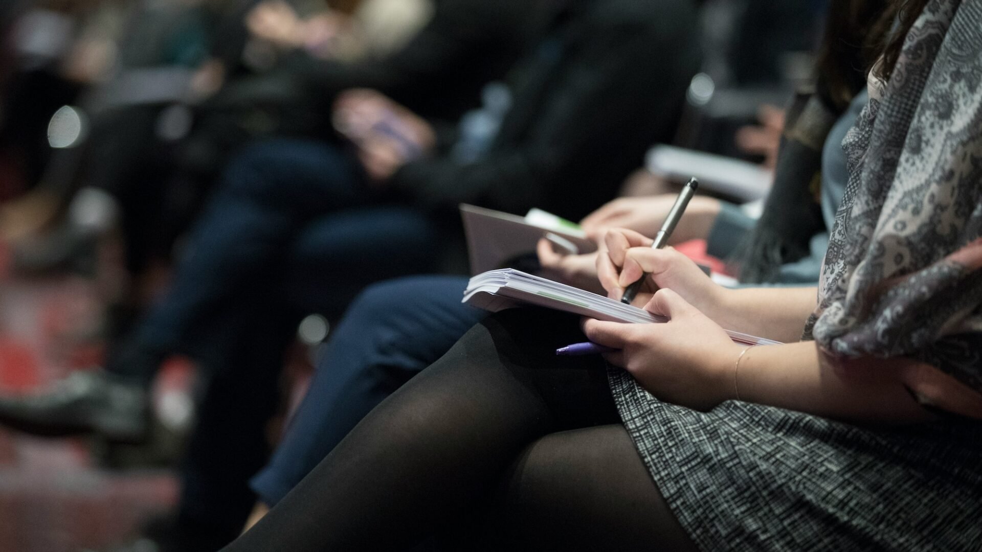 A row of agents sit taking notes in one of the best real estate negotiation classes available in the industry