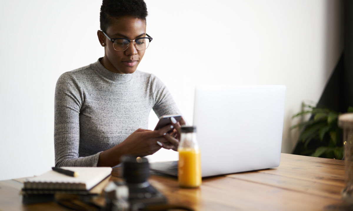 A customer checks her phone for a SMS real estate marketing message from a realtor.