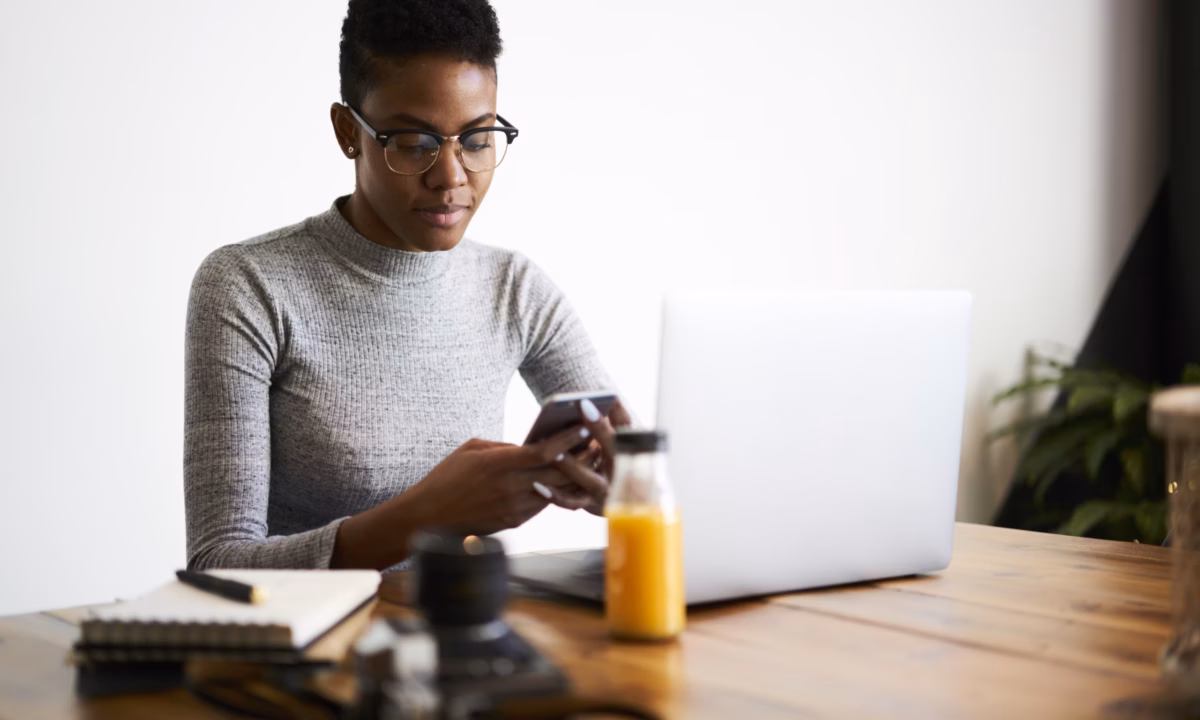 A customer checks her phone for a real estate SMS marketing message from a realtor.