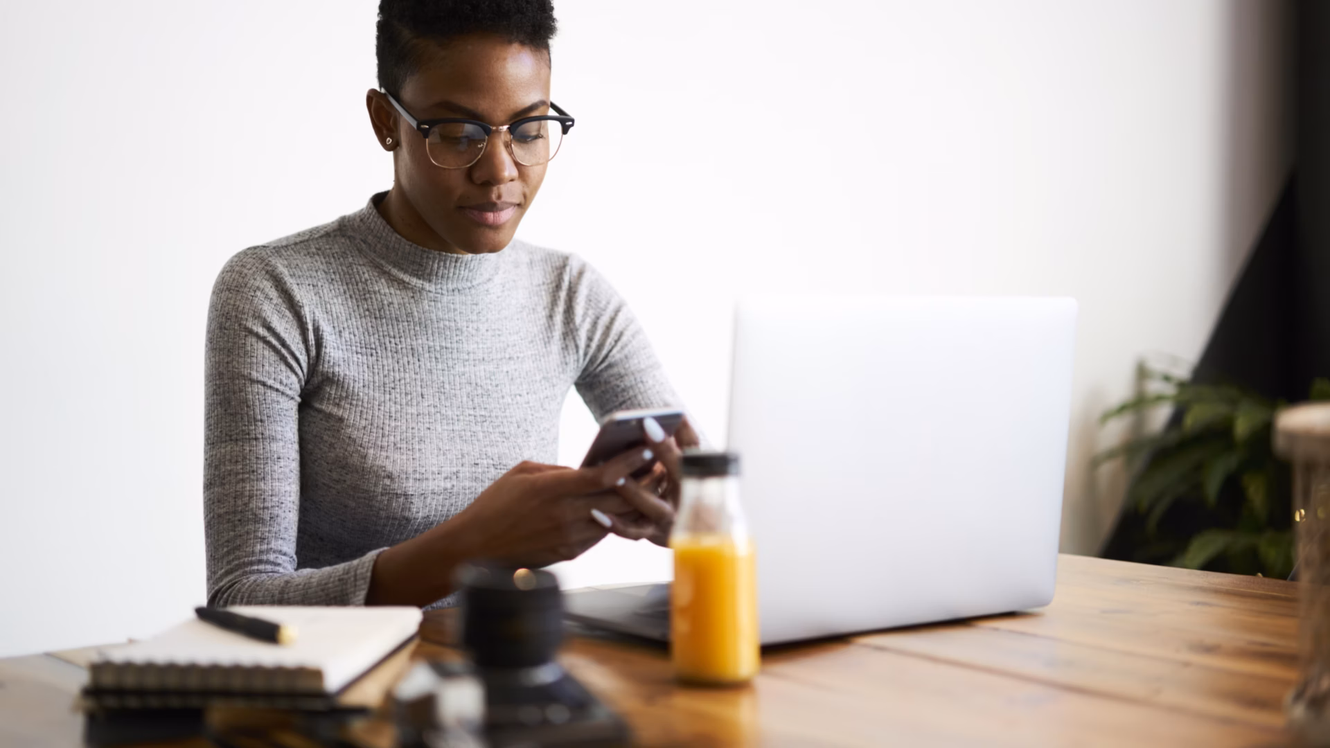 A customer checks her phone for a real estate SMS marketing message from a realtor.