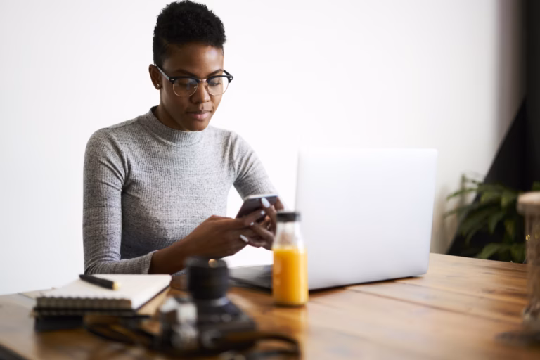 A customer checks her phone for a real estate SMS marketing message from a realtor.