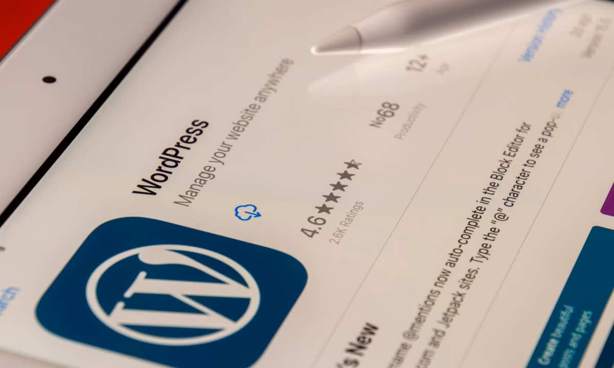 A tablet displays a preview of a real estate website built on WordPress CMS.