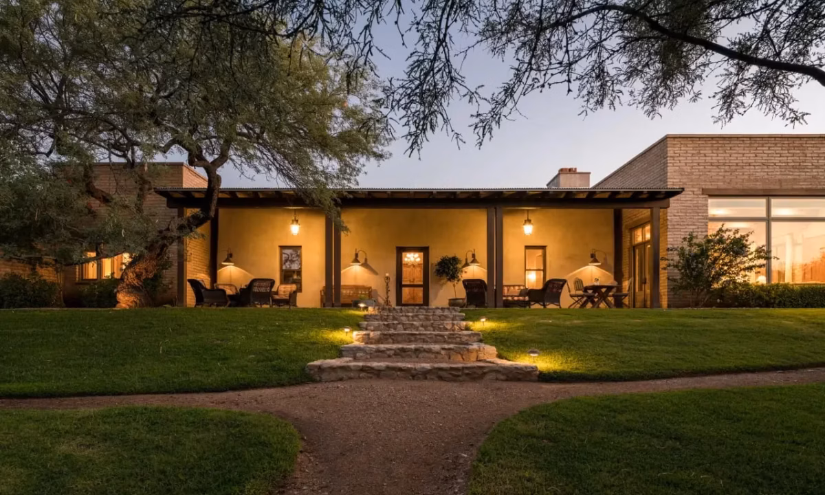 Ranch house exterior during dusk lit by warm yellow lights