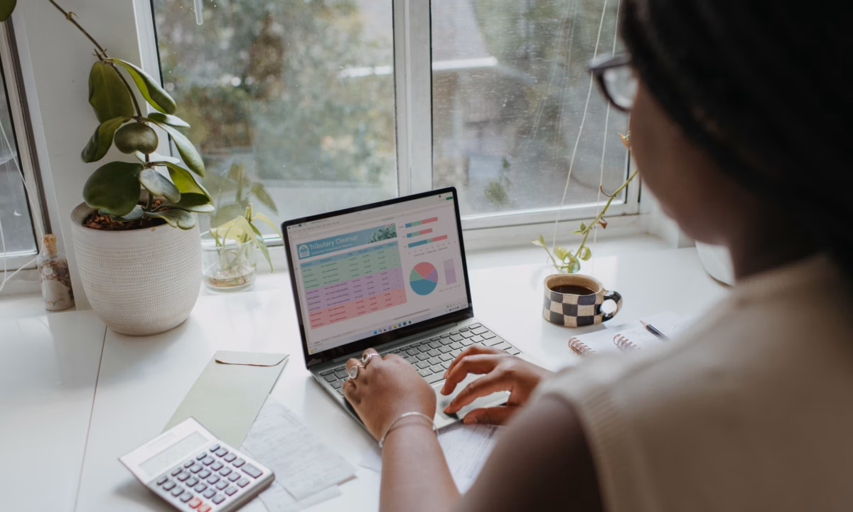 A realtor managing their real estate marketing expenses with the help of a guide on her laptop.