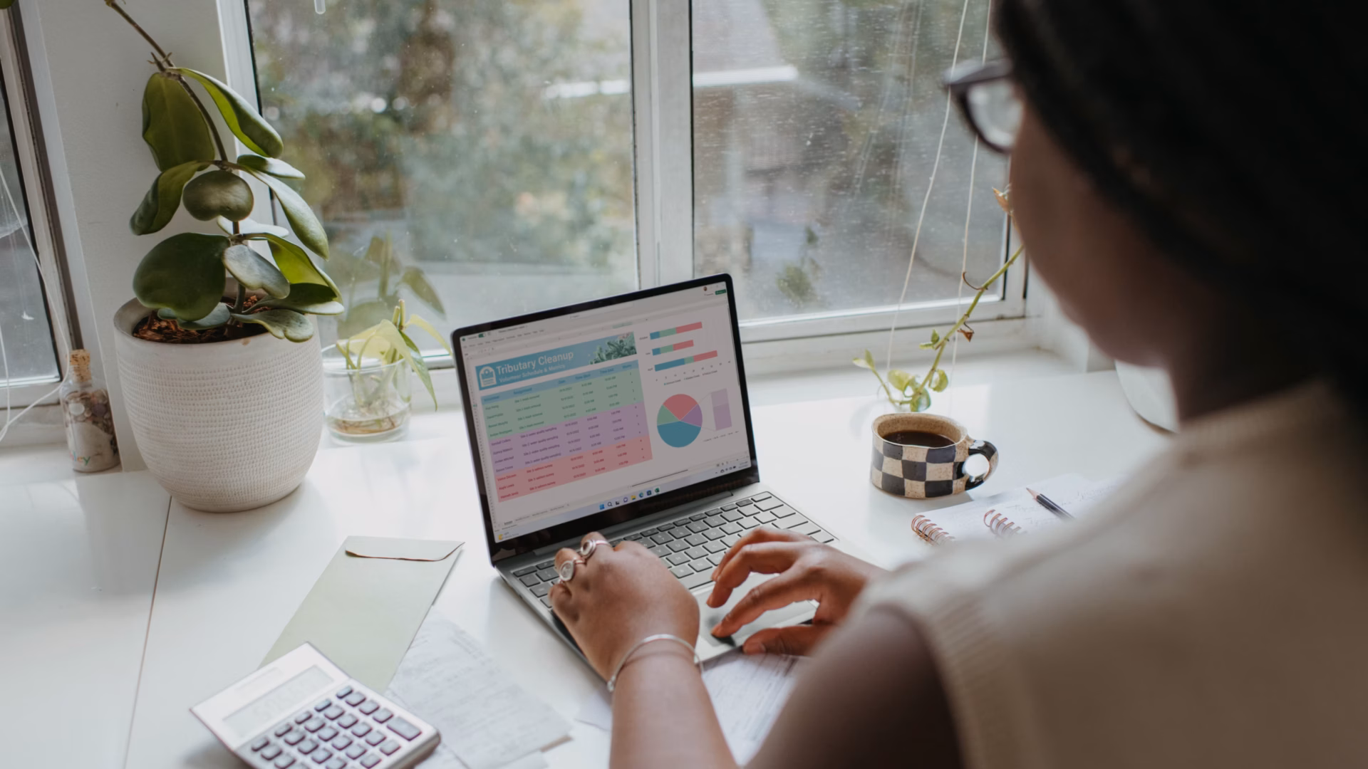 A realtor managing their real estate marketing expenses with the help of a guide on her laptop.