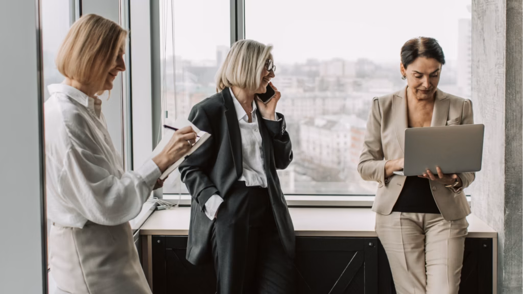 Three female real estate agents standing in the office, collaborates on how to build their marketing plan.