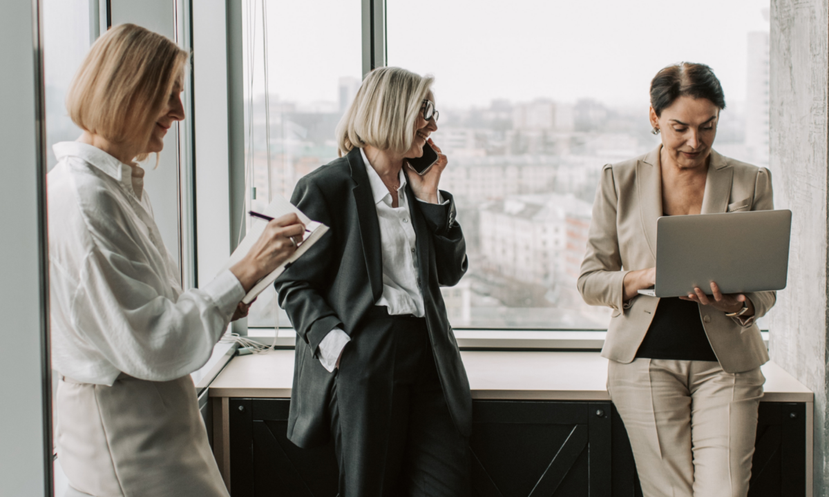 Three female real estate agents standing in the office, collaborates on how to build their marketing plan.