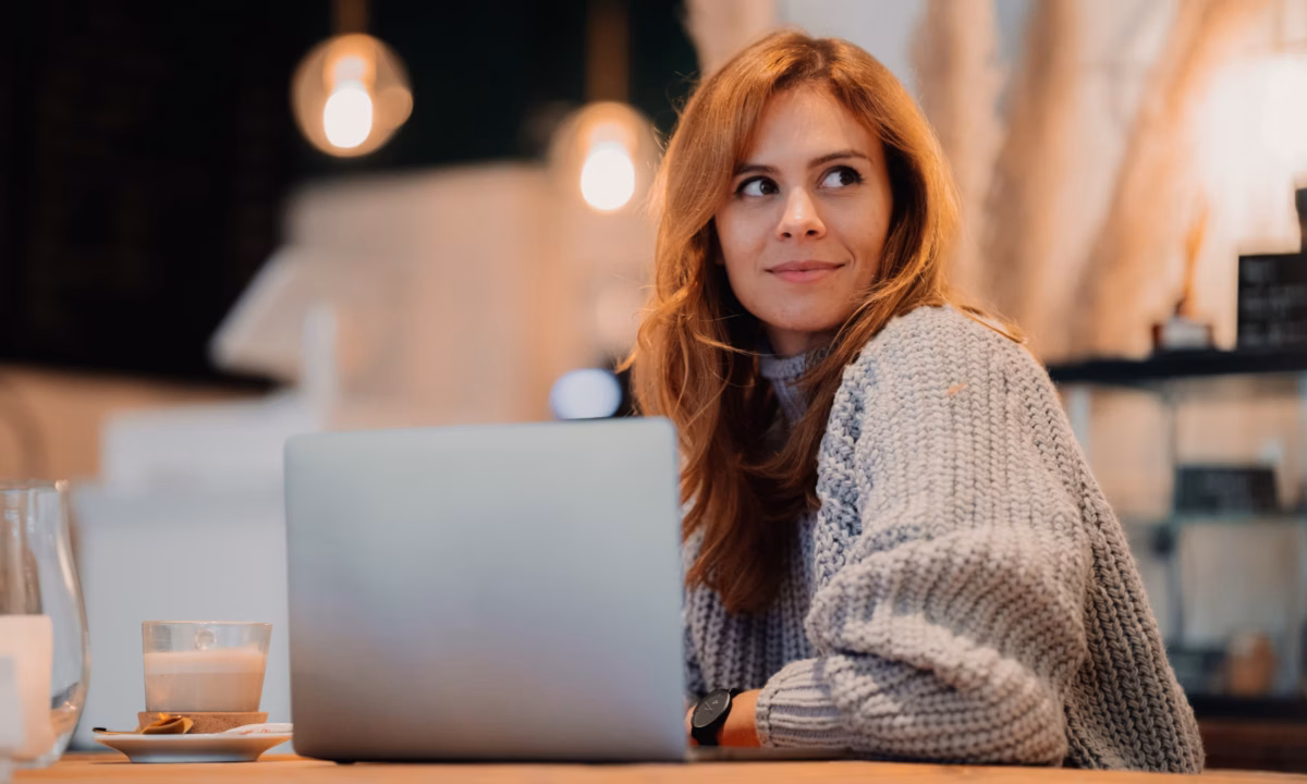 Image of real estate agent sitting at laptop in a coffee shop