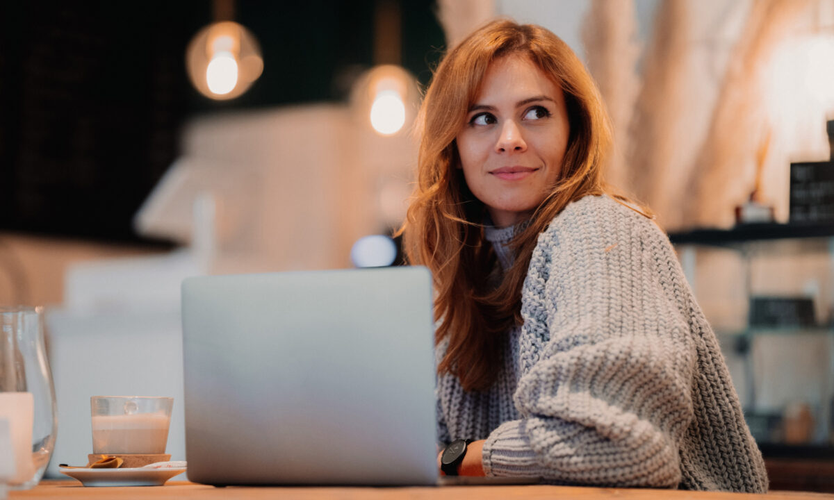 Image of real estate agent sitting at laptop in a coffee shop