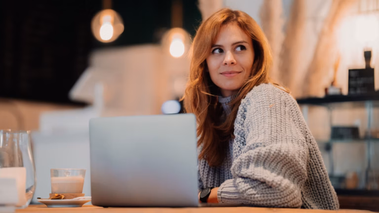 Image of real estate agent sitting at laptop in a coffee shop