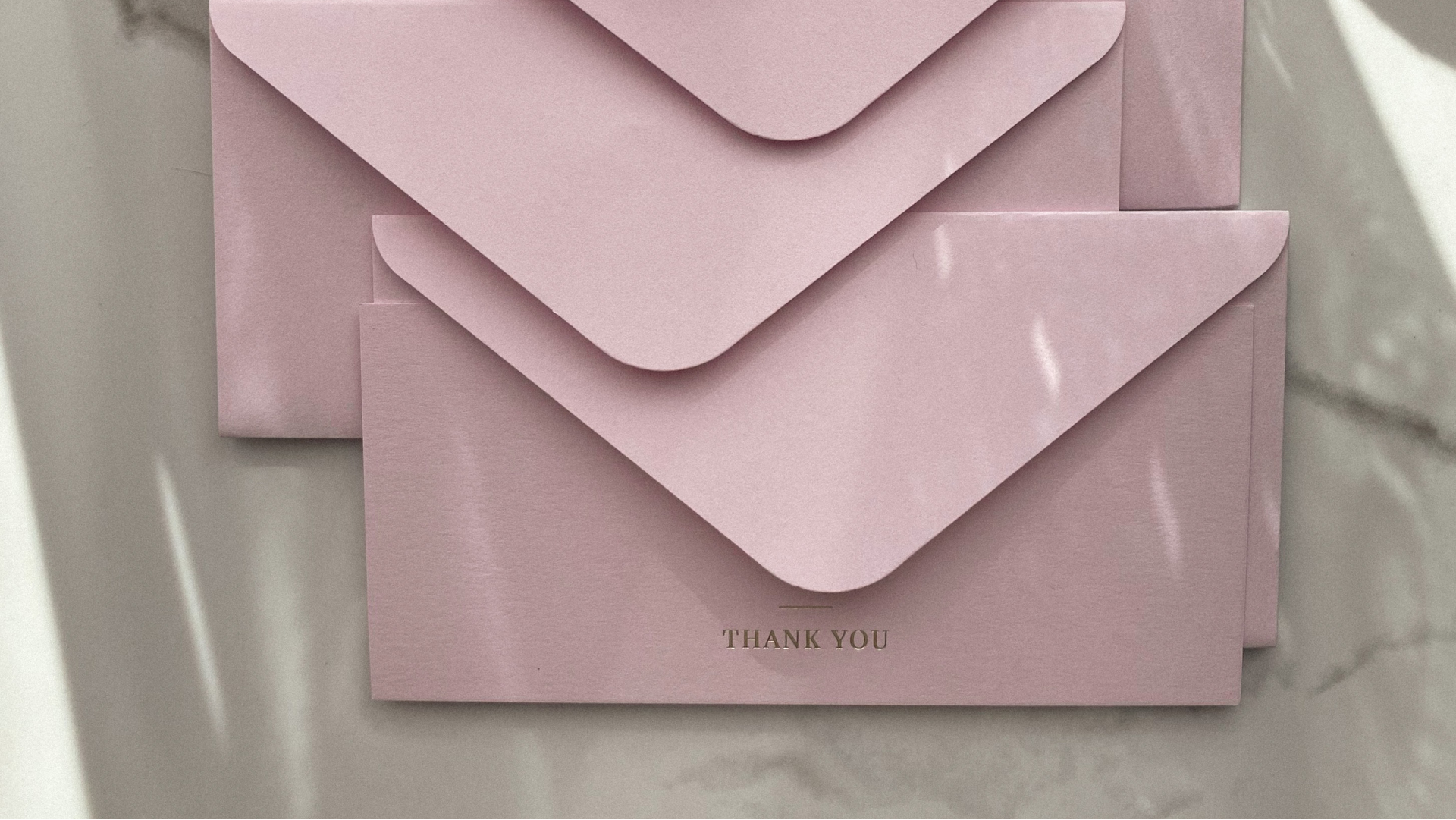 image of pink envelopes stacked up