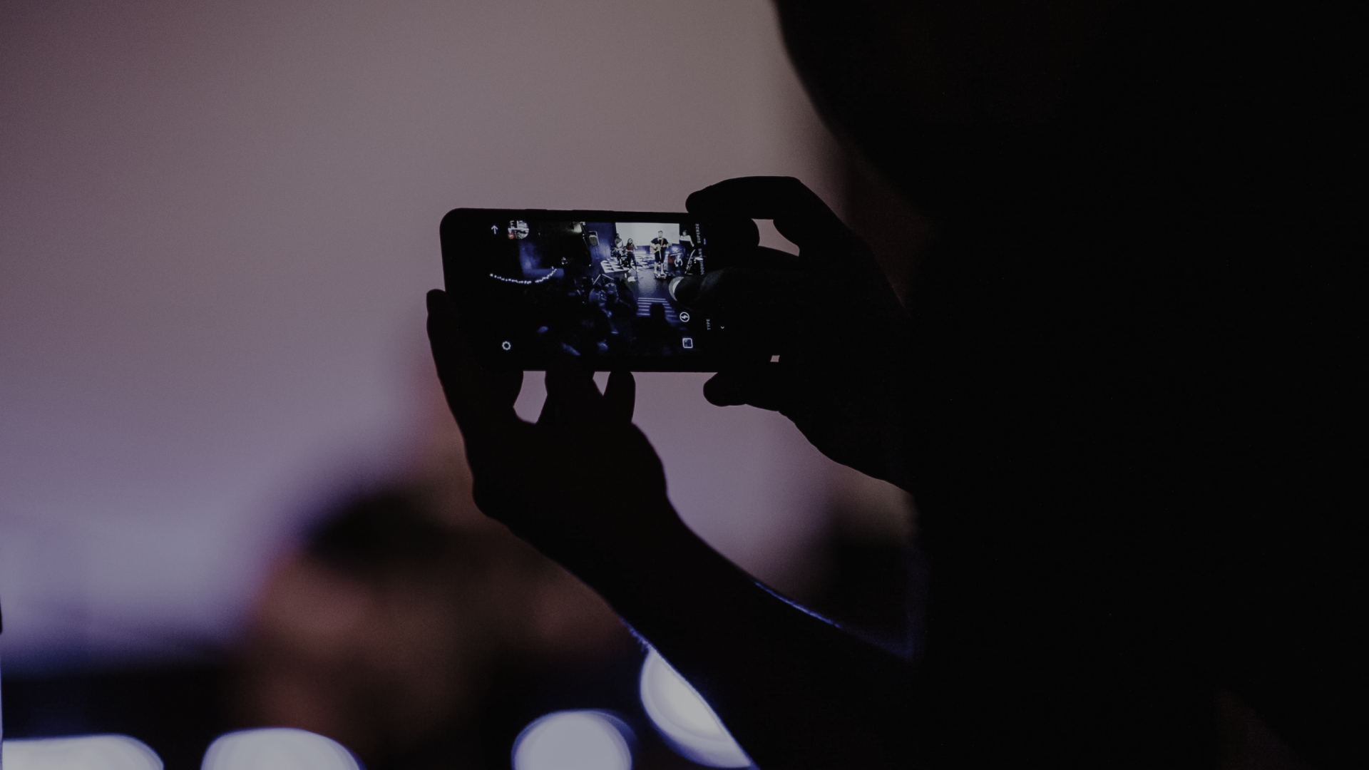image of agent holding up iphone capturing social media content
