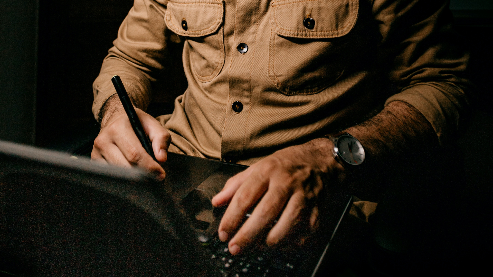 image of man using pen writing on ipad