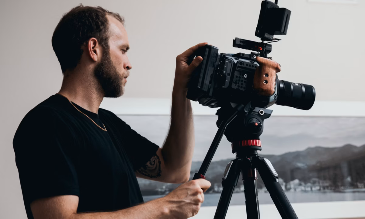 photographer wearing a black shirt using camera and tripod to demonstrate how to take real estate photos
