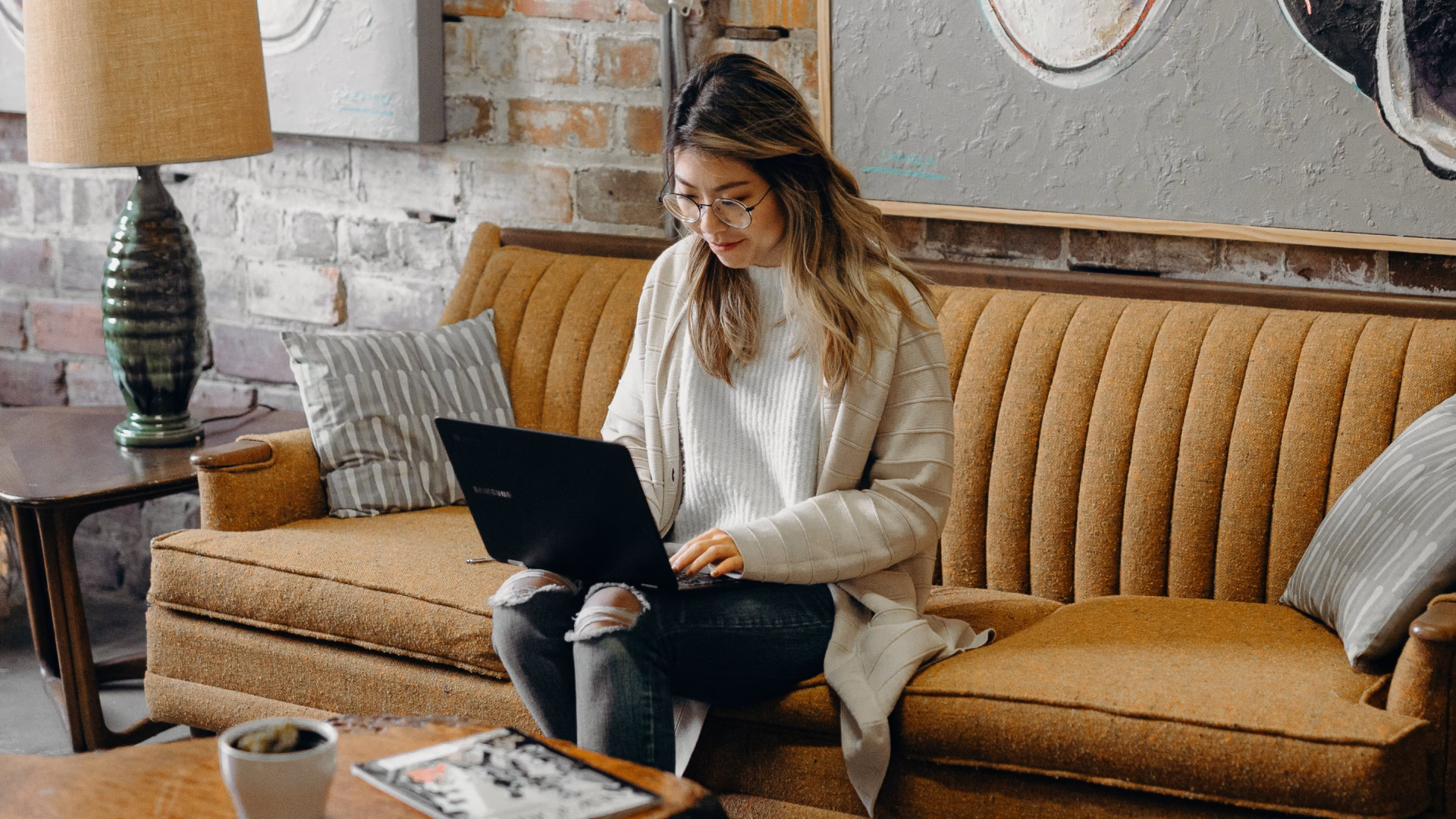 agent sitting on couch reading blog on laptop about real estate email marketing