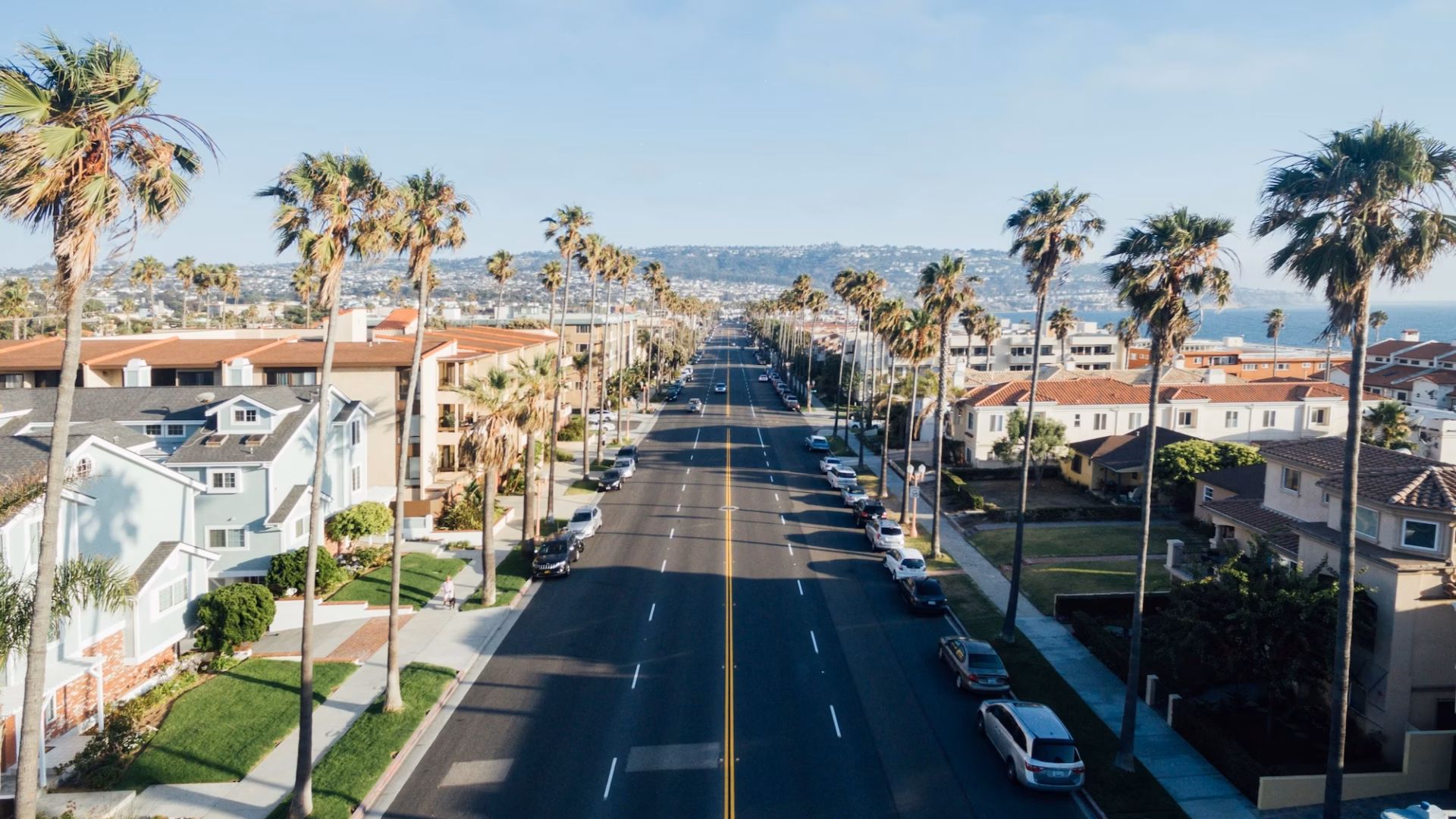 Aerial view of wide street in Rodondo Beach lined with palm trees as a metaphor for the road ahead in terms of how to become a real estate agent in california