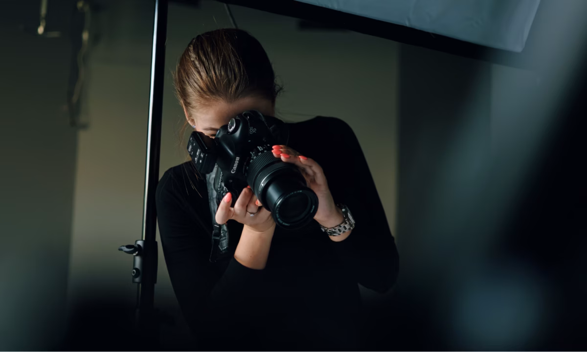 Photographer looks through viewfinder of a digital SLR camera to take some real estate headshots