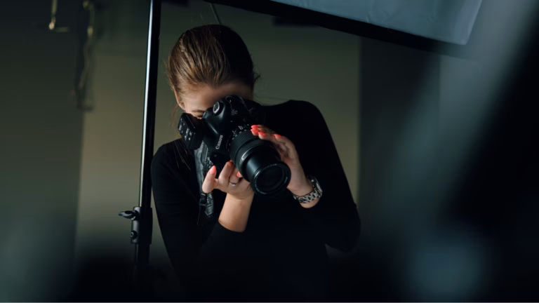 Photographer looks through viewfinder of a digital SLR camera to take some real estate headshots
