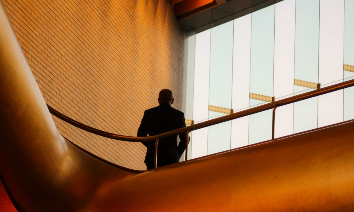 business man standing at top of staircase. Used as decorative image for blog titled What’s the difference between a Realtor and a real estate agent?