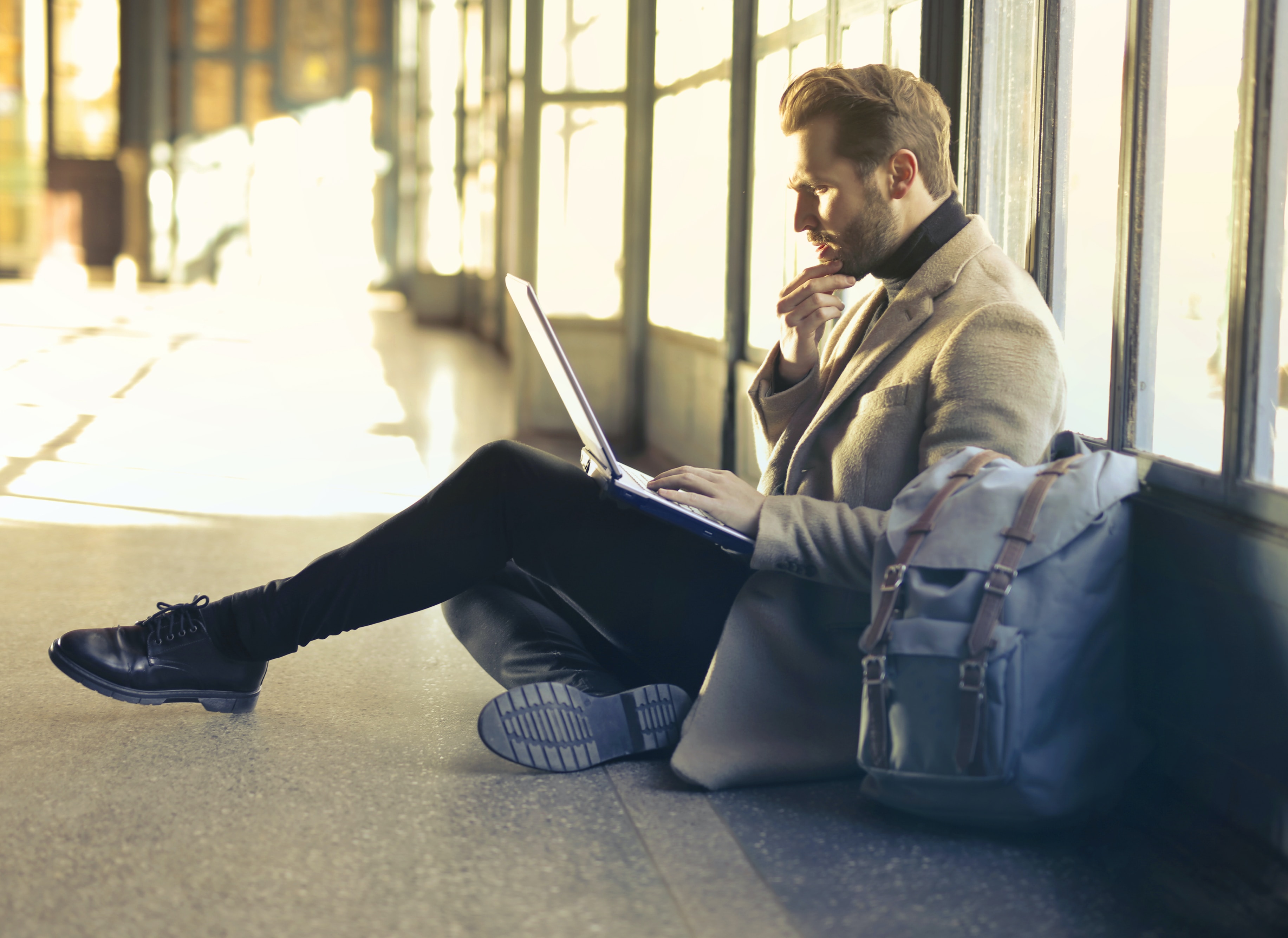 man sitting in airport terminal on laptop