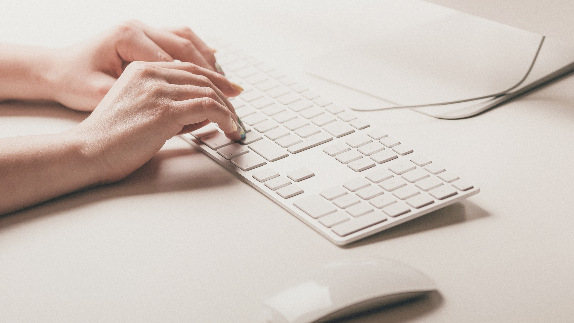 female hands typing on white keyboard