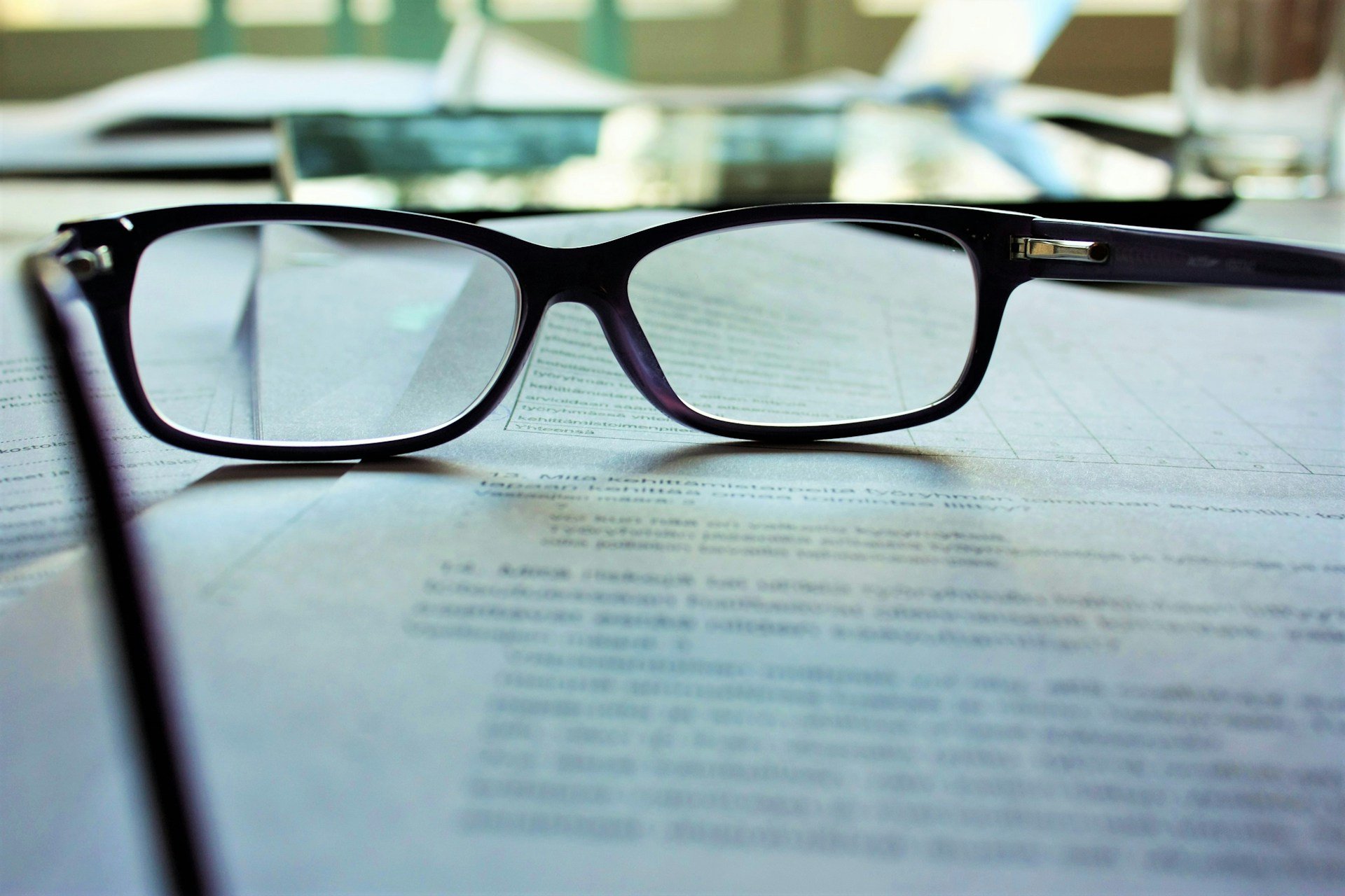 Glasses sitting on top of a real estate referral contract