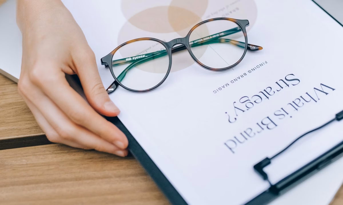 An agent opening a book that says "what is brand strategy" on the front in search of the best real estate slogans and taglines